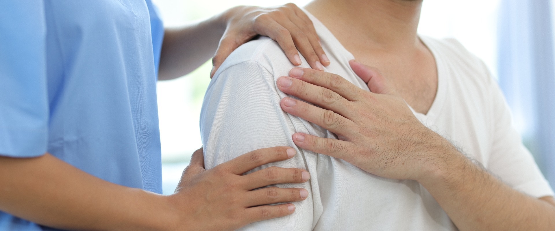 Ein Arzt diagnostiziert die Schulterschmerzen eines Mannes im Untersuchungszimmer eines Krankenhauses. Krankenschwester bei der Massage und Physiotherapie zur Behandlung der Schulter des Patienten.