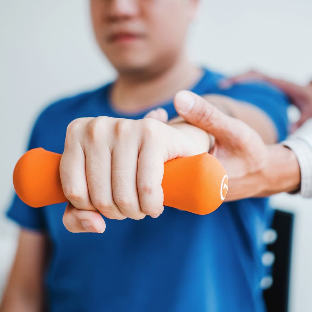 Physiotherapeut Mann gibt Übung mit Hantel Behandlung über Arm und Schulter des Sportlers männlichen Patienten Physiotherapie Konzept